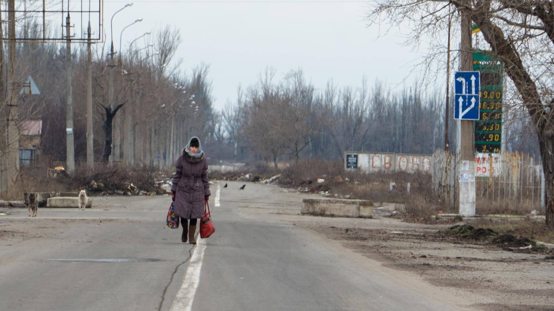 A woman walks through a bombed-out street in Ukraine